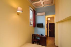 佛罗伦萨Hotel Cardinal of Florence - recommended for ages 25 to 55的客房设有书桌、窗户和床。
