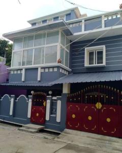 蓬蒂切里Aarudhara Holiday Home (A Home away from Home)的前面有门的蓝色房子