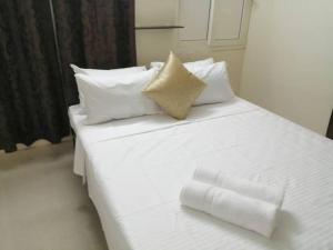 蓬蒂切里Aarudhara Holiday Home (A Home away from Home)的白色的床、白色床单和枕头