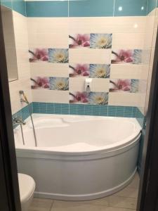 塞格德默苏利塞拉谢丽旅馆的浴室配有浴缸,墙上挂着鲜花