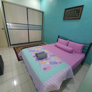 哥打丁宜Ma Maison Homestay Taman Daiman Jaya Kota Tinggi的一间卧室配有一张紫色床和枕头