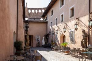 罗马Il Monastero Collection的大楼内带桌椅的小巷