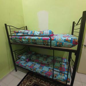 哥打丁宜Ma Maison Homestay Taman Daiman Jaya Kota Tinggi的客房内的2张双层床,配有箱子
