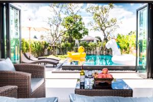 武里南BAAN DALAH POOL VILLA的庭院设有游泳池和带饮品的桌子。