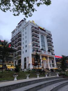 三岛县Camellia Luxury Hotel Tam Đảo的一座白色的建筑,前面有一个喷泉