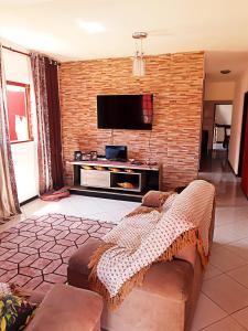 乌巴图巴Ubatuba Beach House的客厅配有沙发和砖墙电视