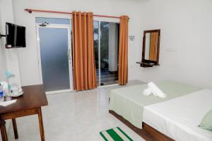 尼甘布Araliya Lagoon Park Resort的酒店客房设有两张床和电视。