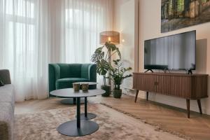 阿尔克马尔RITCH Hotel Alkmaar的客厅配有电视和绿色沙发