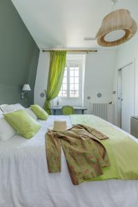 阿涅勒L'Hôtel Particulier - Paris Asnières的一间卧室配有一张绿色的大白色床。