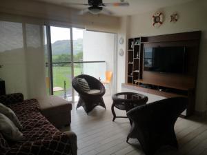 查梅Playa Caracol, Punta Chame, Panamá的客厅配有沙发、椅子和电视