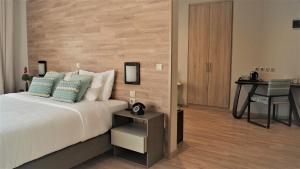 拉里萨公园酒店的一间卧室配有一张床和一张桌子及椅子