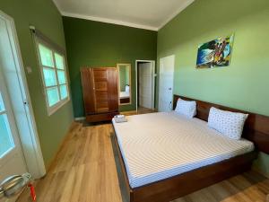圣多美Residencial Avenida Geovanni的一间设有床铺的卧室,位于一个拥有绿色墙壁的房间