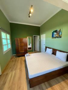 圣多美Residencial Avenida Geovanni的一间设有一张大床的卧室,位于带绿色墙壁的房间