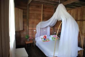 巴亚索拉诺Paraiso Escondido的一间卧室配有一张带天蓬的白色床