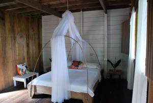 巴亚索拉诺Paraiso Escondido的一间卧室配有一张带天蓬的床