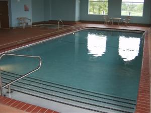 Warsaw华沙帕克菲尔德酒店的一个带两把椅子的大型游泳池