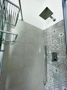 帕尔马La Rocca Luxury Apartment的一间带淋浴的浴室和瓷砖墙