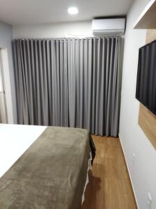 戈亚斯州上帕莱索Chapada Confort Flats的一间卧室配有一张床和一台电视。