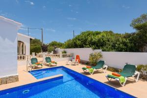 卡拉恩波特Villa CLAUDIA Menorca的一个带躺椅的游泳池和一个游泳池