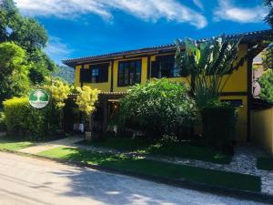 巴拉-沙希Pousada Aroeira的一条种有植物的街道上的黄色房子