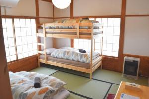 妙高Myoko House的带窗户的客房内的两张双层床