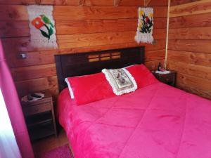柯纳里佩Cabañas El Diuco en Coñaripe 4的一间卧室设有红色的床和木墙