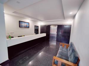 迈索尔Suvarna Elite - Premium Apartment Hotel的客厅配有沙发和墙上的电视