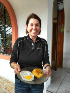 巴克里索莫雷诺港Casa de Nelly的拿着一盘鸡蛋和饼干的女人