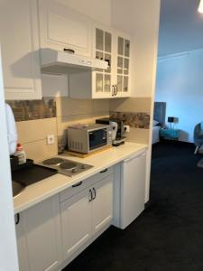 大戈里察WooW Apartments的厨房配有白色橱柜和台面上的微波炉