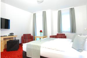 赛巴特班森赫姆晨旅馆的酒店客房,配有一张床和两张红色椅子