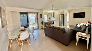 班达伯格Home away from home - Modern luxury in central Bundaberg的客厅配有沙发和桌子