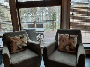 伊马特拉奇乌伦别墅度假屋的带庭院的客房内配有两把椅子和一张桌子