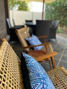 班达伯格Home away from home - Modern luxury in central Bundaberg的庭院配有椅子、枕头和桌子