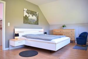 波茨坦El Ático的一间卧室配有一张床和一张蓝色椅子