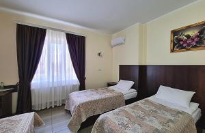 NovoselytsyaГотель "Валерія"的酒店客房设有两张床和窗户。