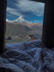 卡兹贝吉Kazbegi Twins的享有雪覆盖山脉美景的床