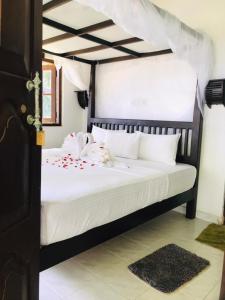 坦加拉Serenity Beach Cabanas的卧室配有黑色和白色的床以及白色枕头。