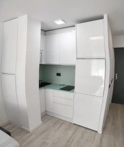 多列毛利诺斯Torre Saltillo的白色的厨房配有白色橱柜和冰箱。