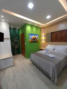 皮帕Chalés Pedra da Pipa的一间卧室设有一张大床和绿色的墙壁