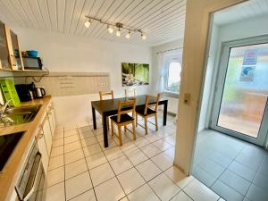 维宁根3-Zimmer Haus 85qm mit Balkon bis zu 8 Personen的厨房以及带桌椅的用餐室。