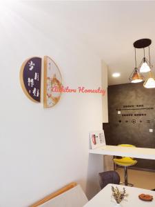吉隆坡Aishiteru Homestay的墙上有桌子和时钟的房间