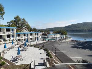 乔治湖Lakefront Terrace Resort的享有湖上度假胜地的正面景色,配有椅子和遮阳伞