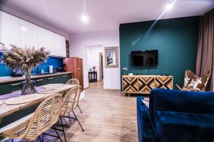 瓦乌布日赫AP Apartment's Gdańska的客厅配有桌子和蓝色的墙壁
