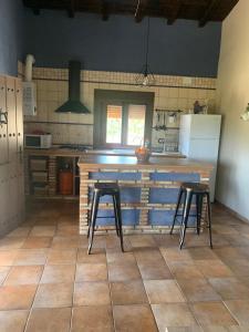埃尔托尔诺Casa Rural Canchal Madroñeras ***的厨房配有2张凳子和1个柜台