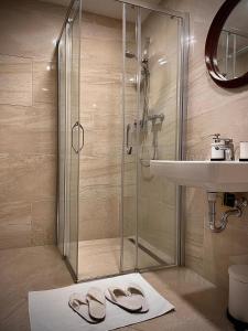 布拉格Harfa Apartment 30的带淋浴、水槽和2个拖鞋的浴室