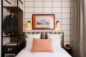 巴黎Hôtel Moderniste的一间卧室配有一张带白色枕头的床和一张照片
