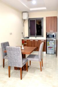 麦地那Salsbil Almasi Hotel的一间厨房,内设一张木桌和椅子