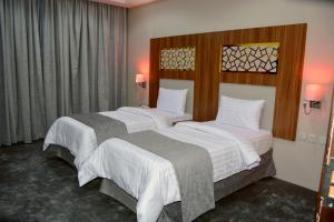 麦地那Salsbil Almasi Hotel的酒店客房,配有两张带白色床单的床
