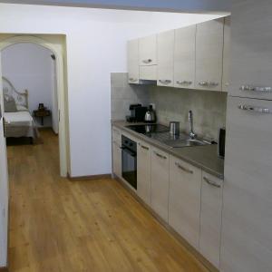 普拉托Appartamento Antico Pozzo的厨房配有白色橱柜和水槽