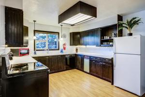 西黄石Geyser Getaway的厨房配有木制橱柜和白色冰箱。